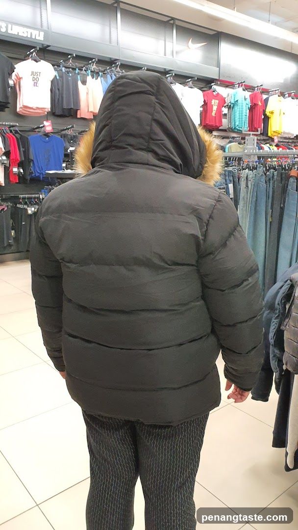 Person wearing a puffer jacket in a clothing store