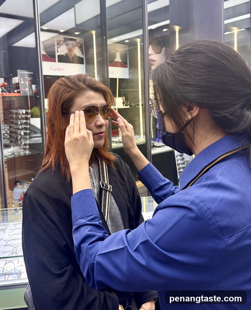 Optician assisting customer with sunglasses