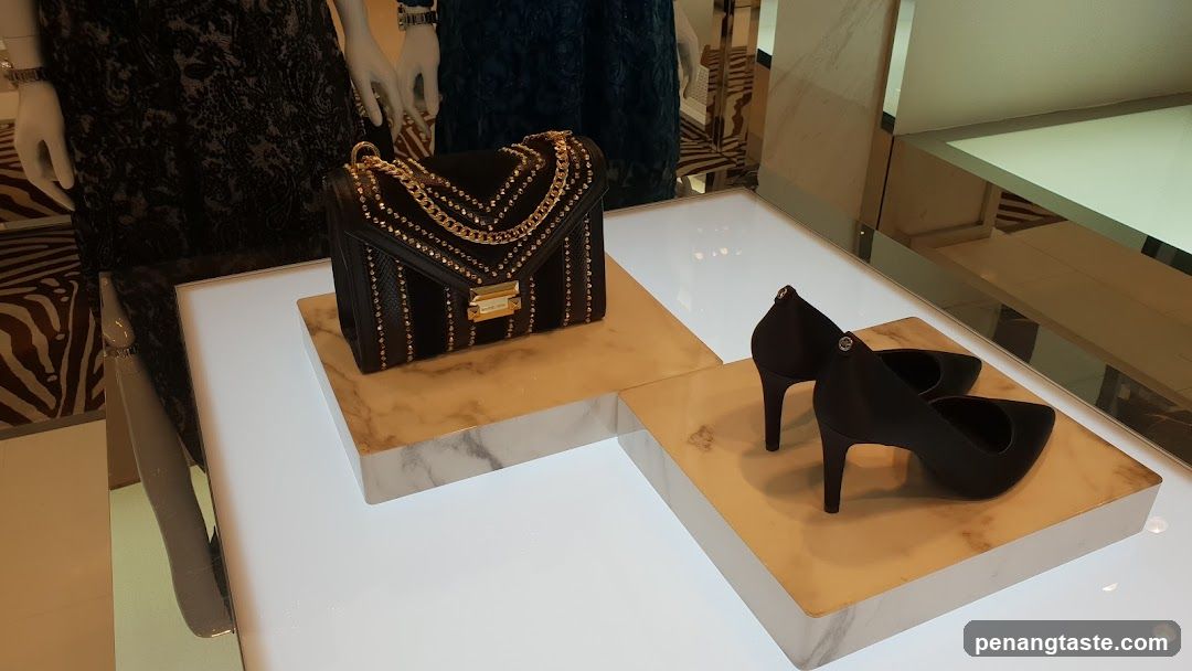 Black handbag and heels on display