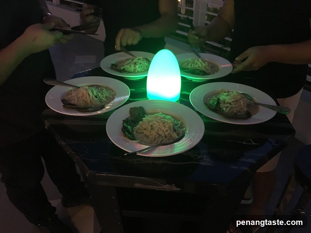 People gathered around a table with bowls of noodles