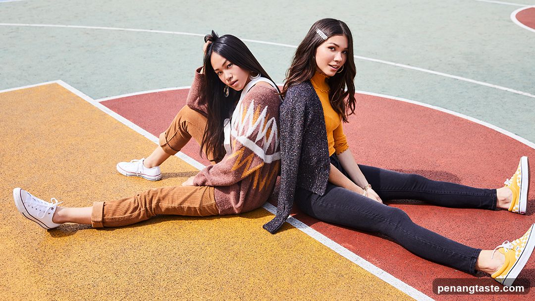 Two young women sitting on a colorful court