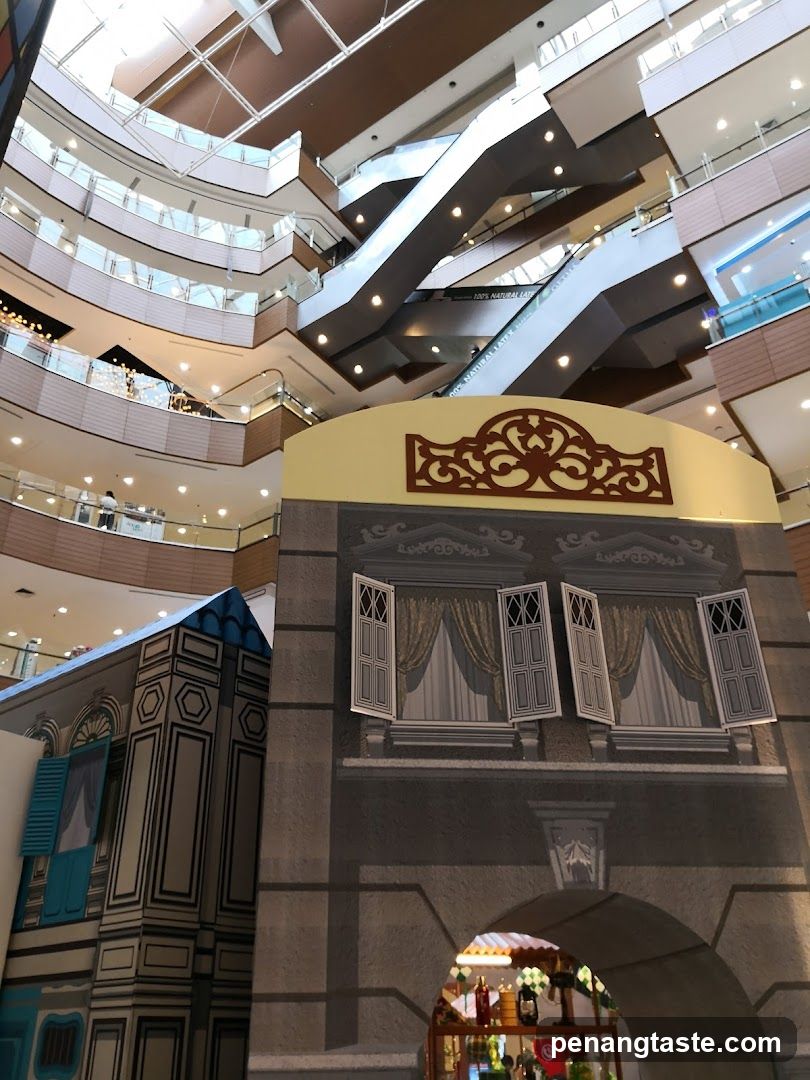 Interior of a multi-level shopping mall with escalators and decorative facades.