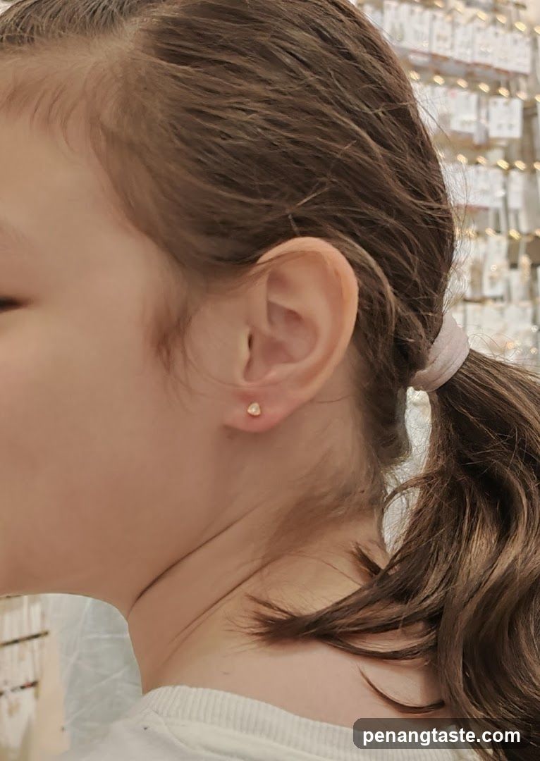 Close-up of a young girl's ear with a small stud earring