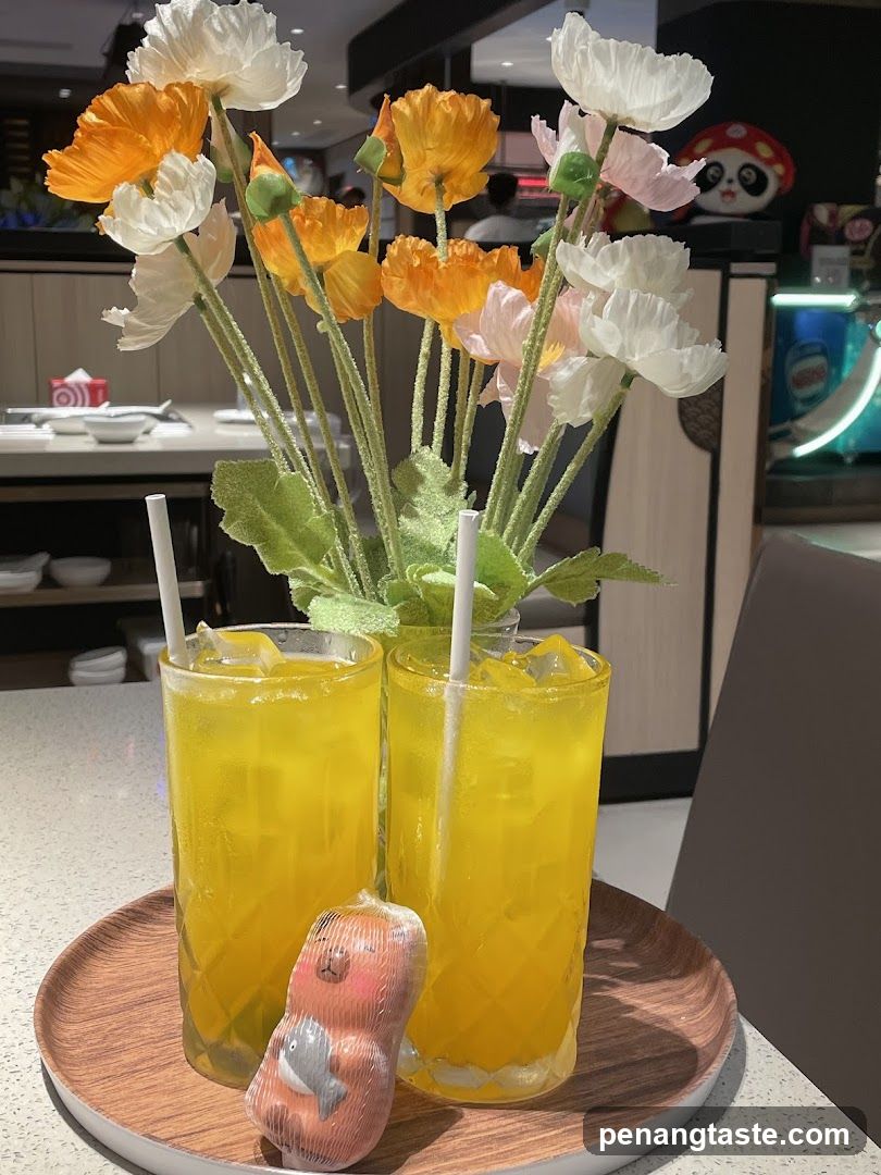 Two yellow drinks with a decorative item on a tray