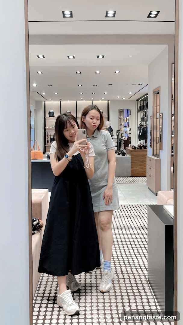Two Women Taking a Mirror Selfie in a Store