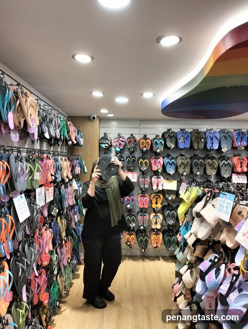 A person holding a phone in a flip-flop store