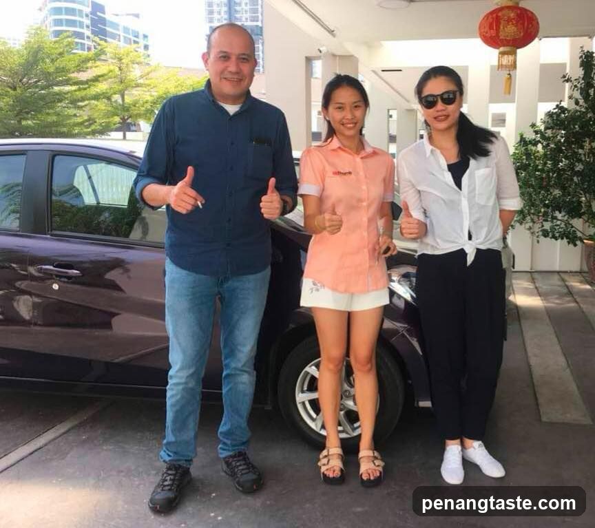 Three people posing with a car