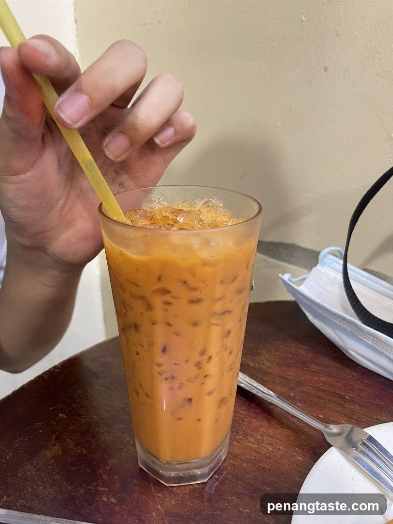 Hand holding iced tea with straw