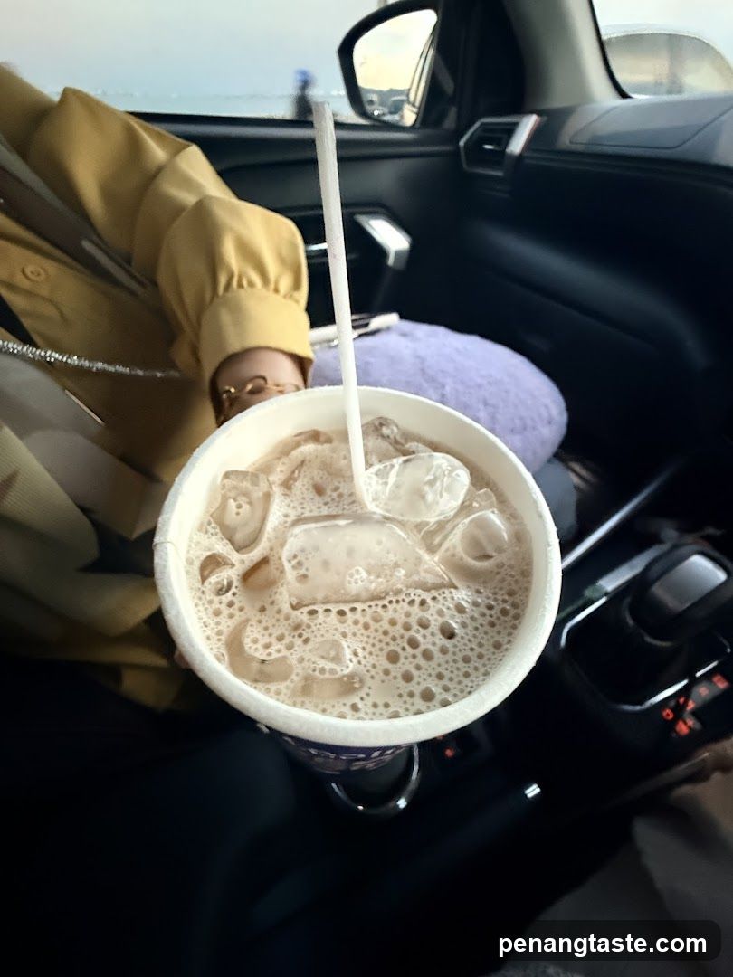 Person in car holding iced beverage
