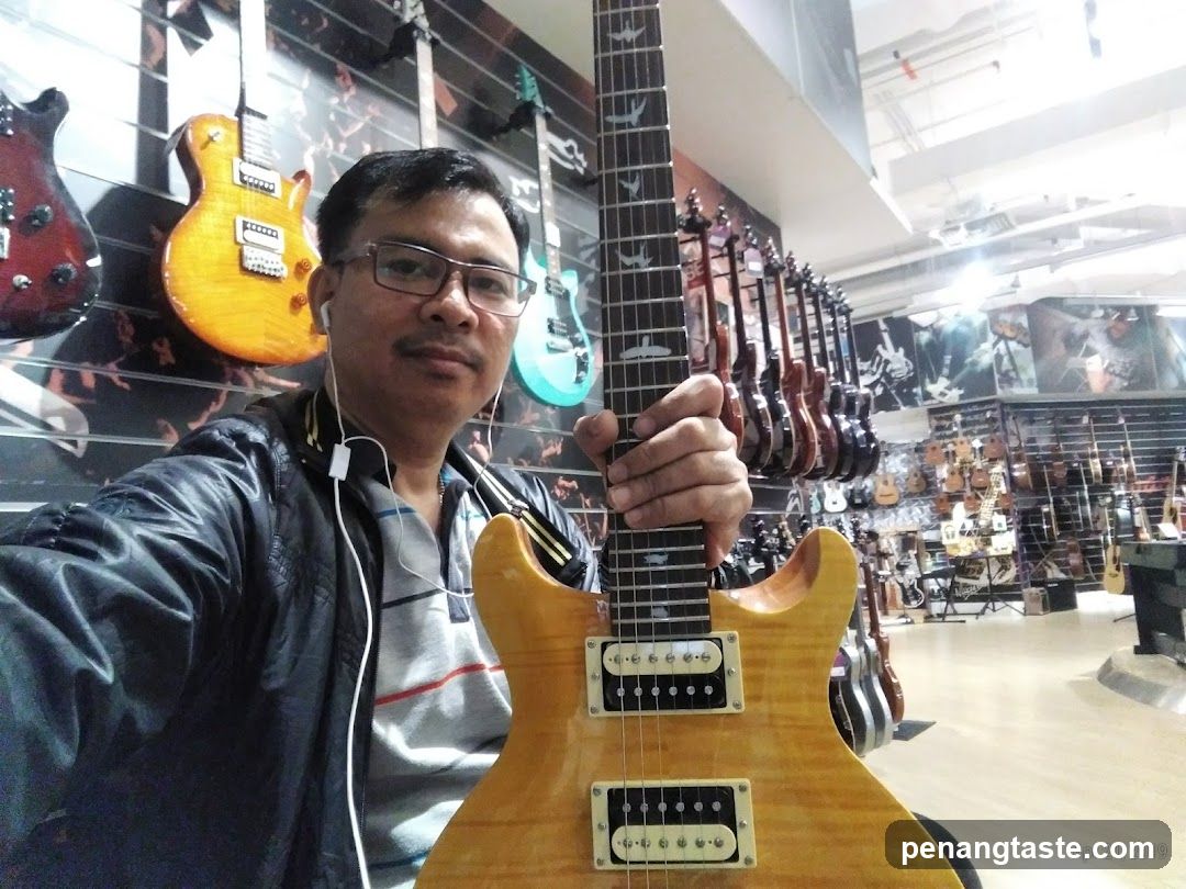 Man holding a guitar in a music store