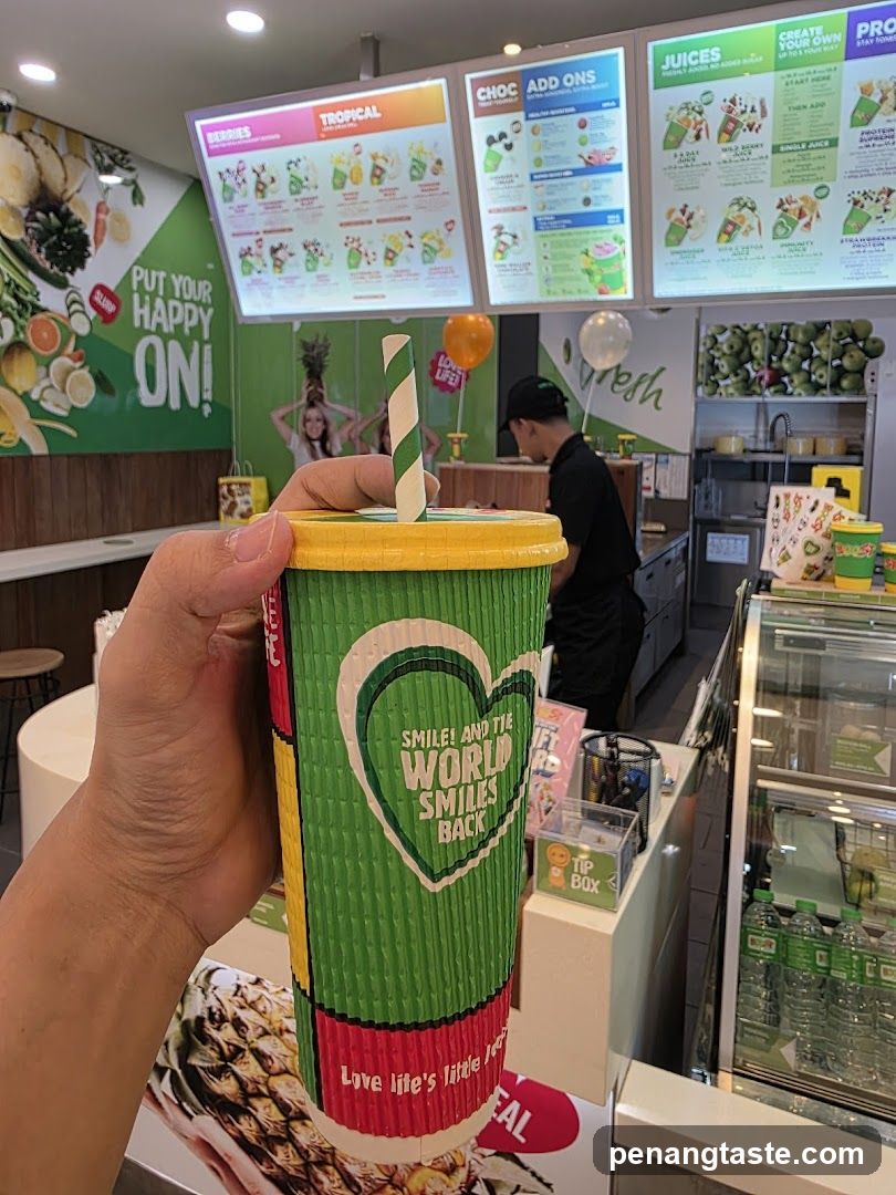 Customer holding a juice cup inside a juice bar