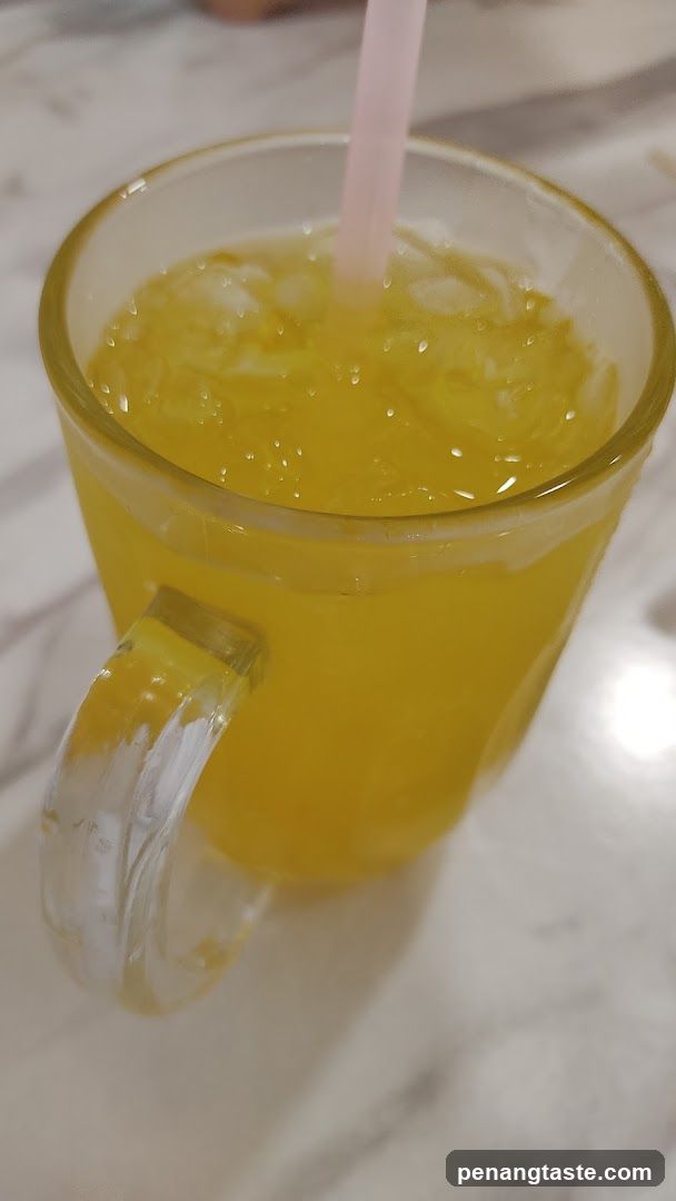Yellow beverage in glass mug with straw