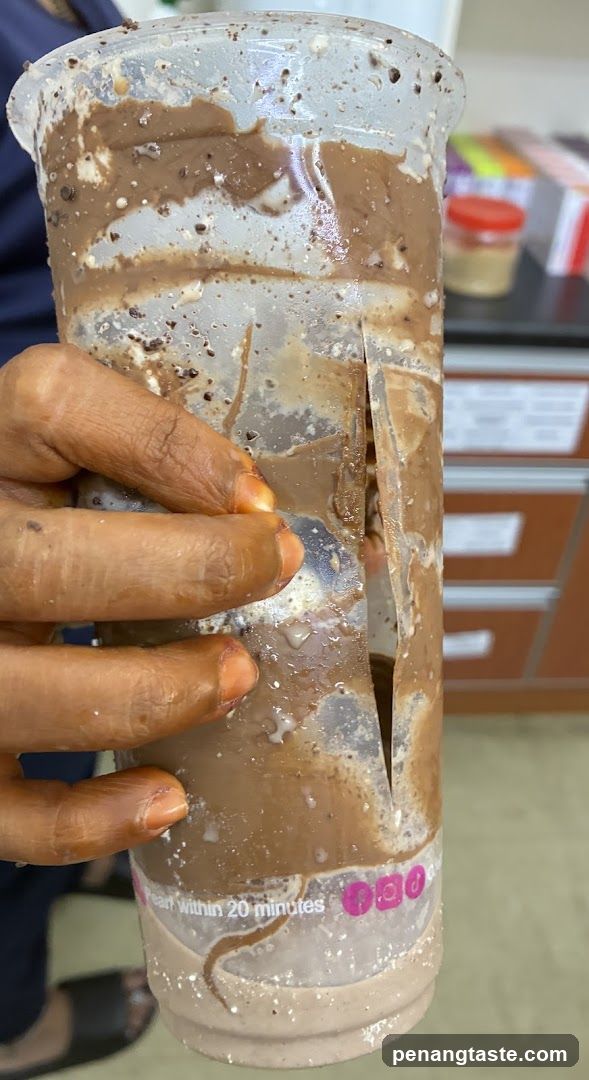Hand holding a damaged drink cup