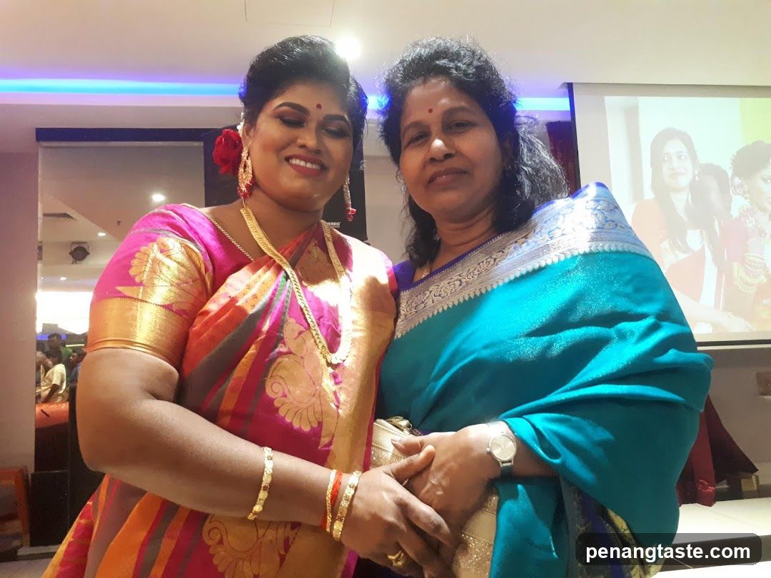 Two women in traditional attire posing indoors