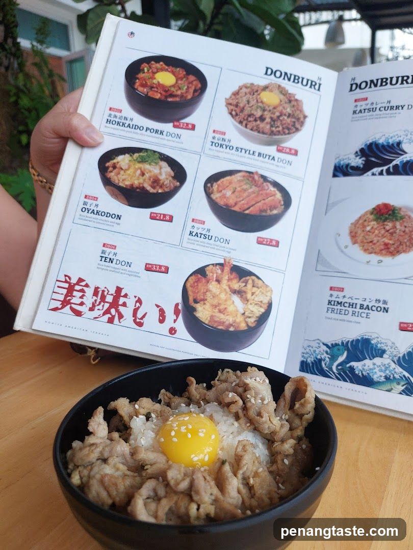 Bowl of rice with meat and egg on table