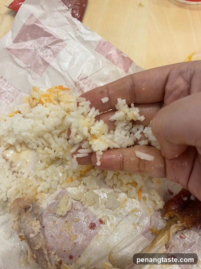 Hand holding rice with food remnants