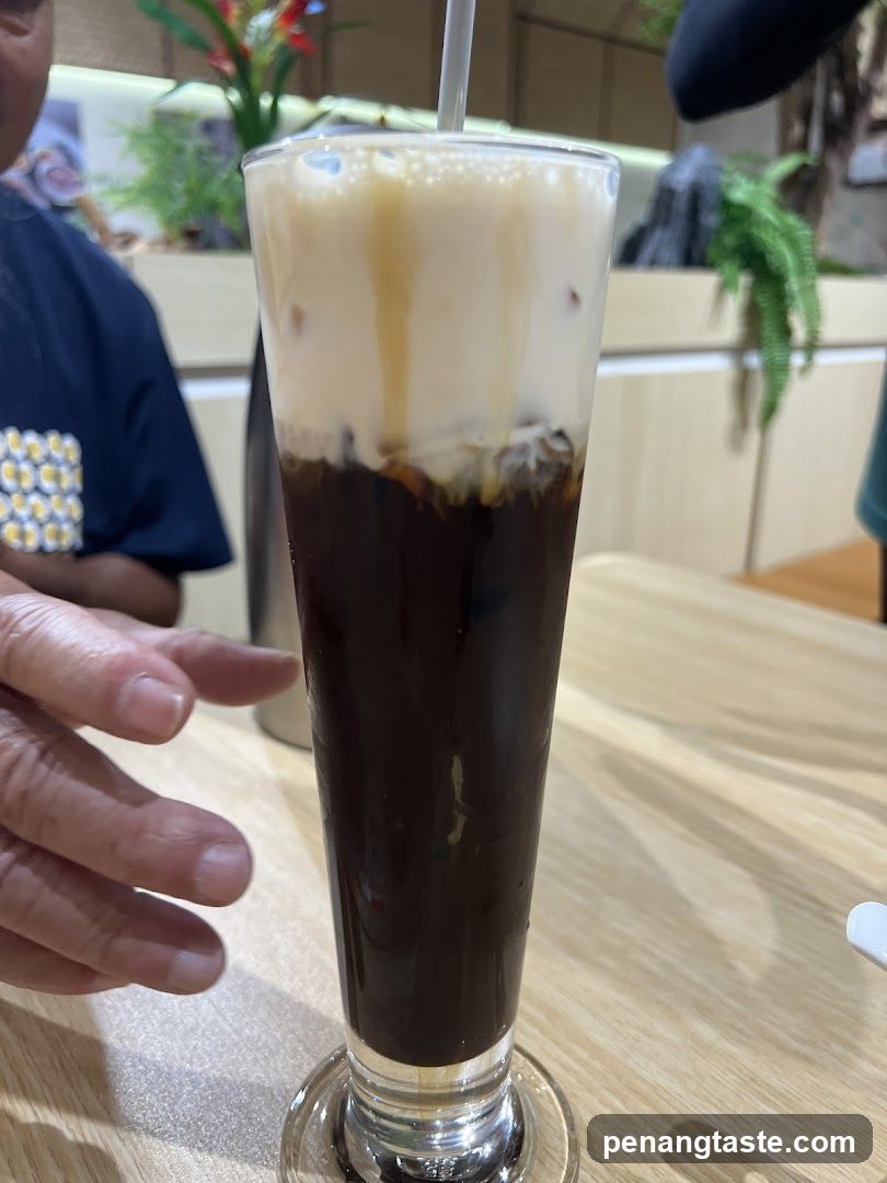 Iced coffee drink in a tall glass with a straw