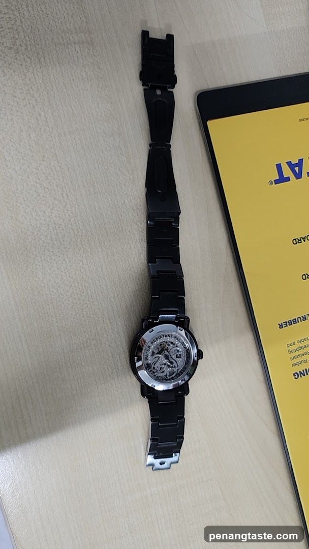 Watch on Table Next to Printed Material