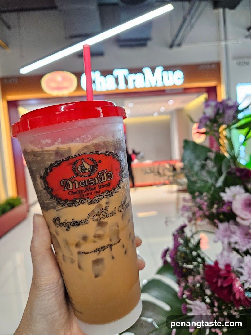 Hand holding ChaTraMue drink in shopping mall
