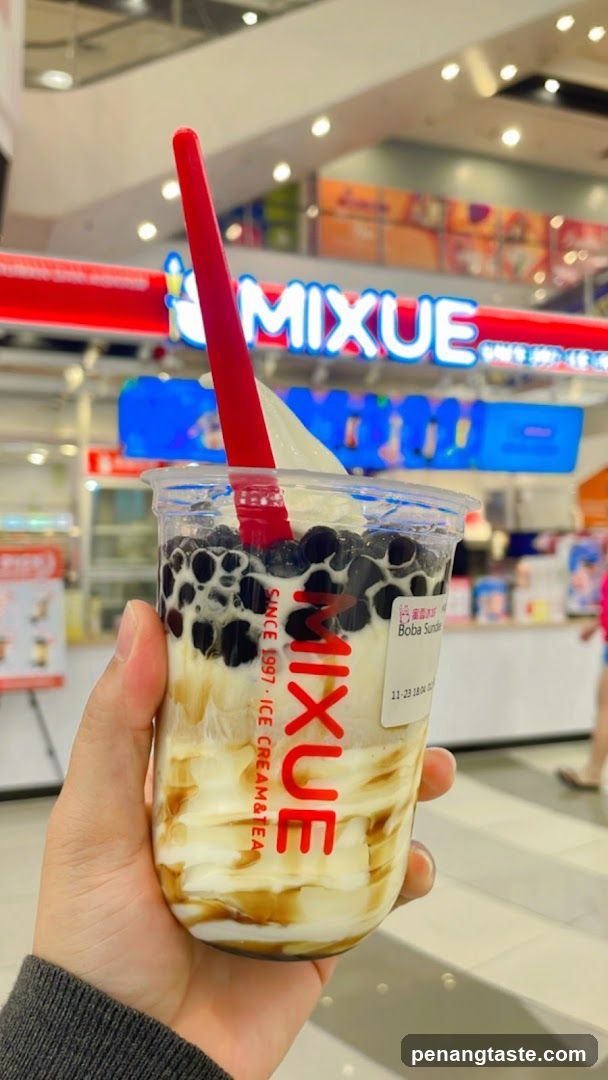 Hand holding Mixue drink in shopping mall