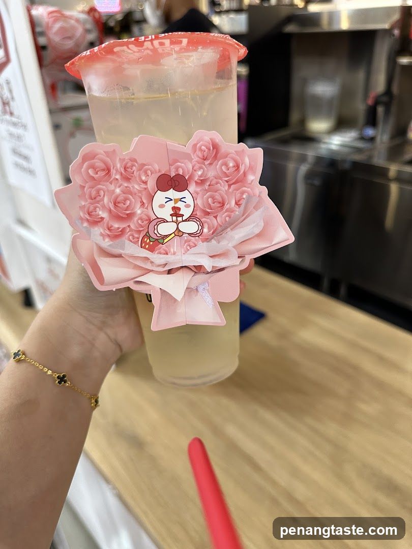 Hand holding a drink with decorative cup cover