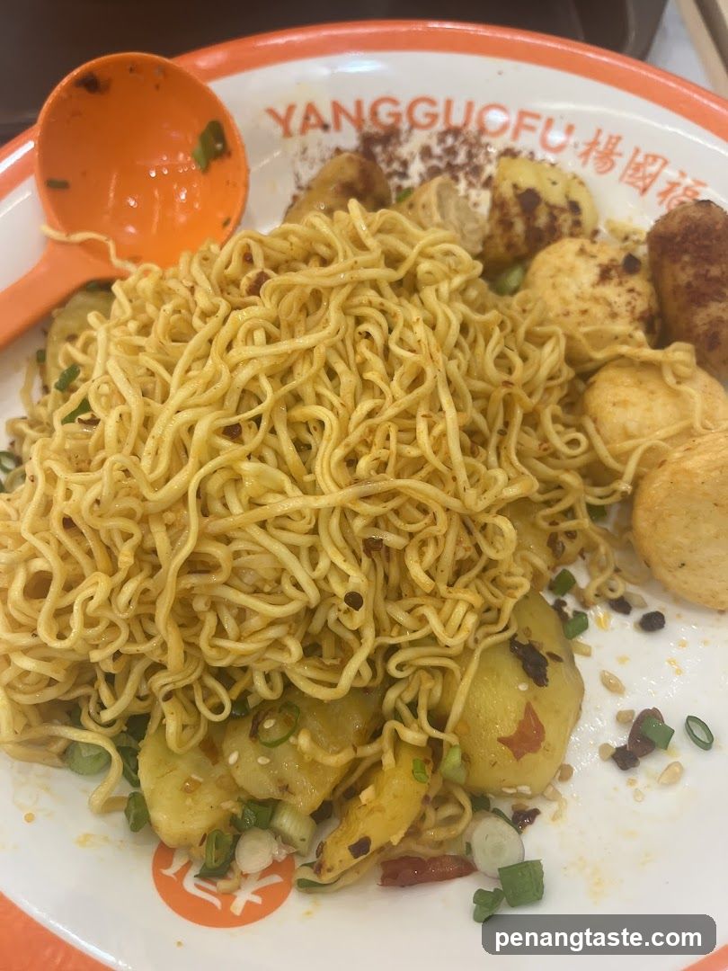 Noodle dish with fried potatoes and garnishes