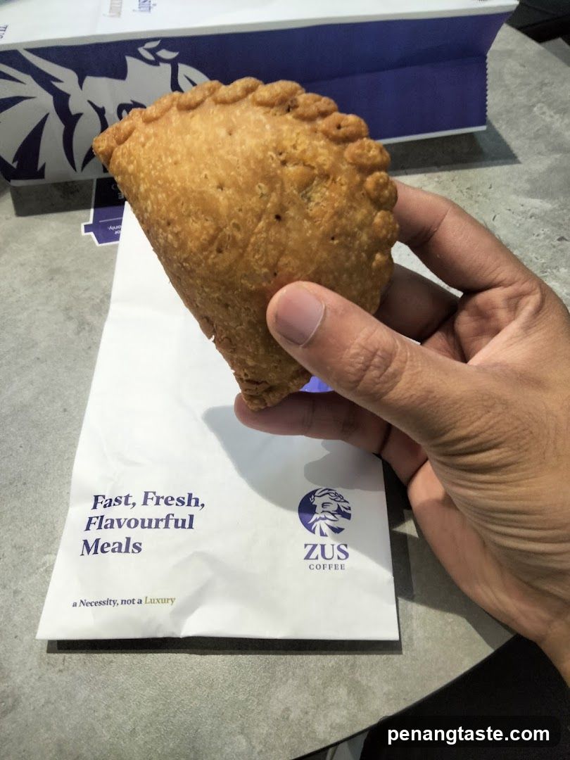 Hand holding pastry with branded packaging