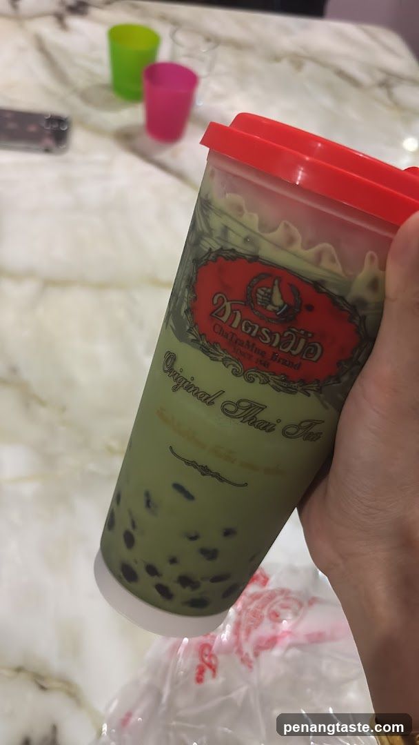 Hand holding Thai tea drink
