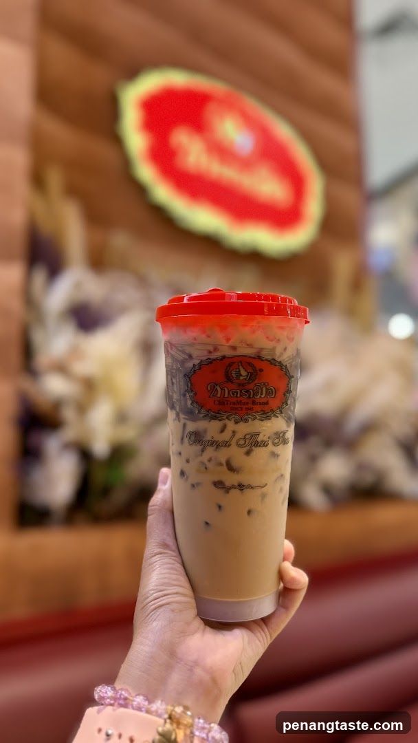 Hand holding Thai tea drink
