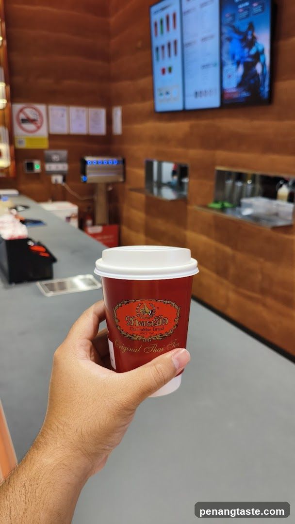 Hand holding a red cup in a coffee shop interior