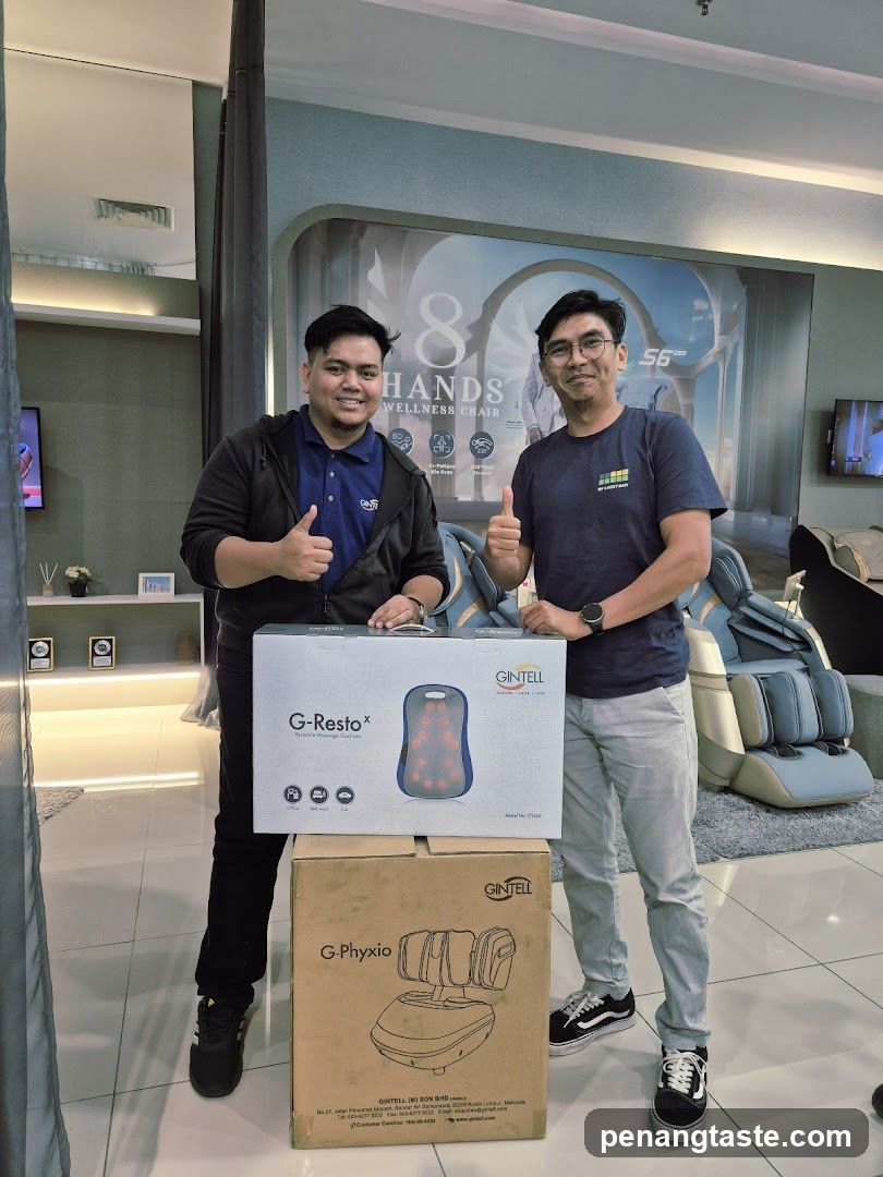 Two men posing with product boxes in a showroom
