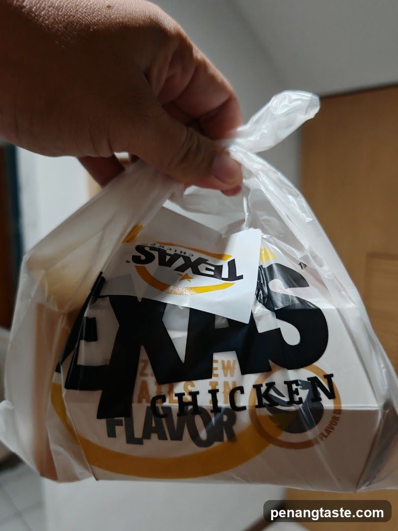 Hand holding Texas Chicken bag