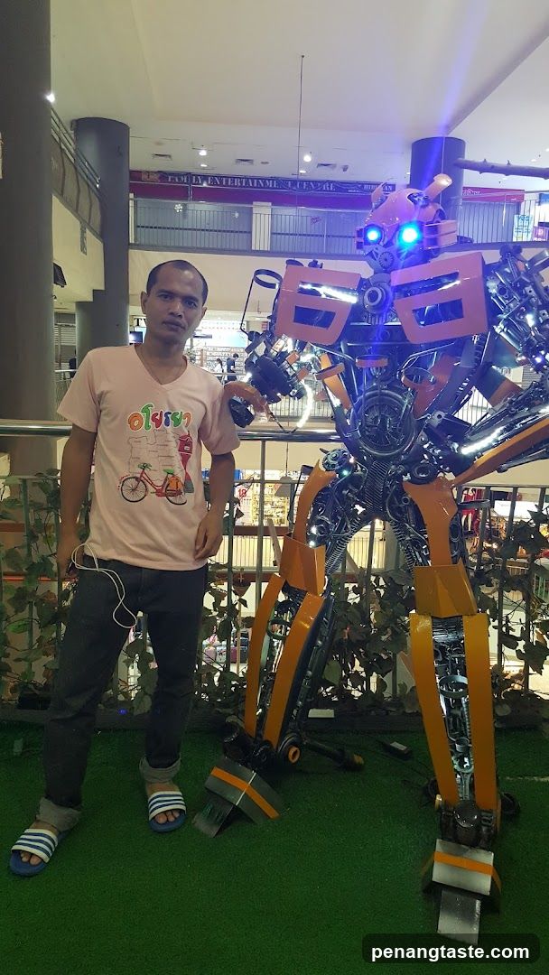 Man with Robot Sculpture in Mall