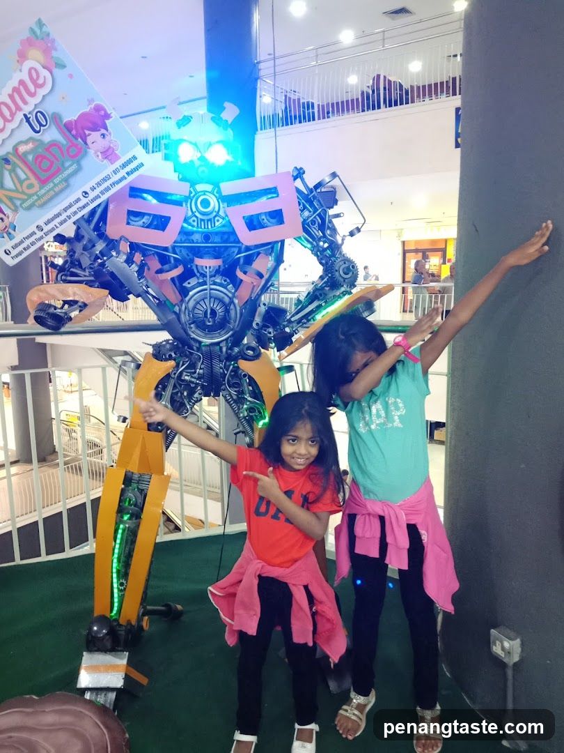Children posing with robot display in shopping mall