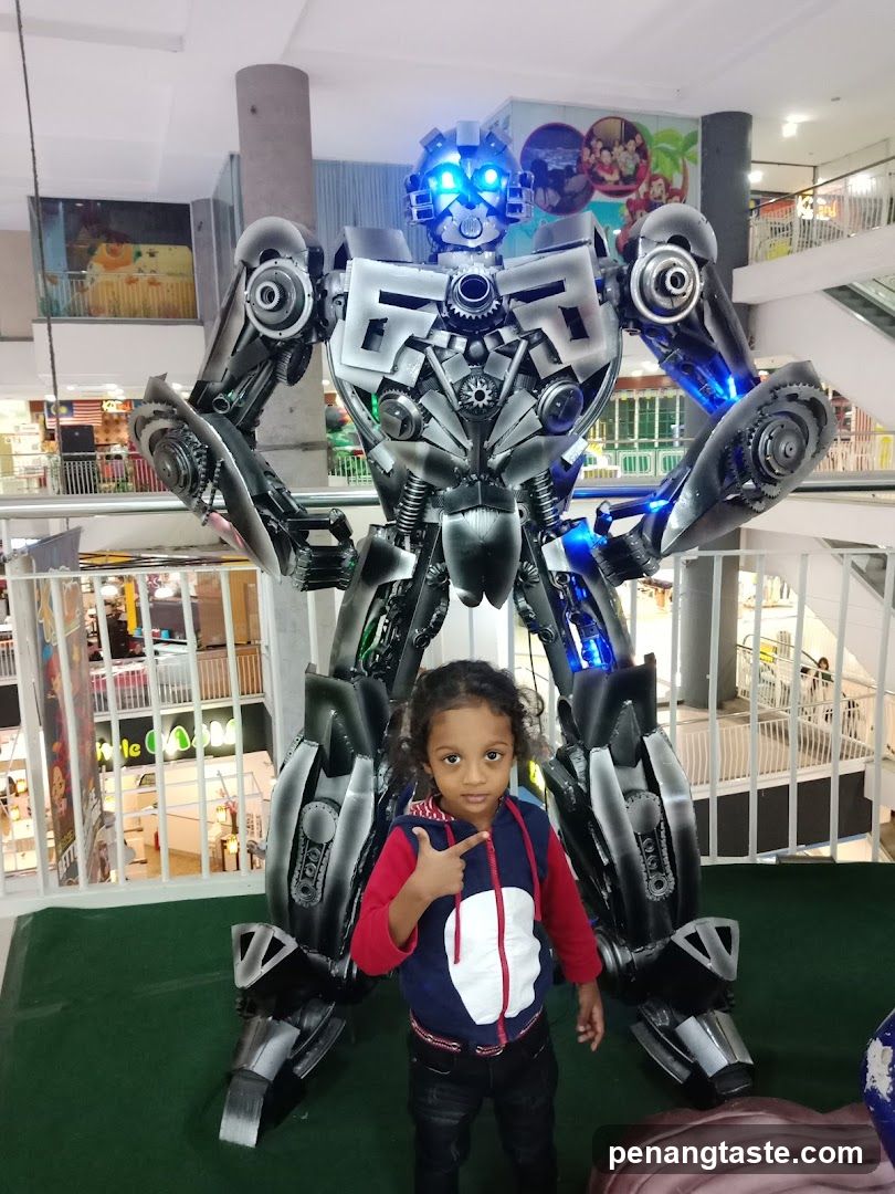 Child posing with robot display in shopping mall