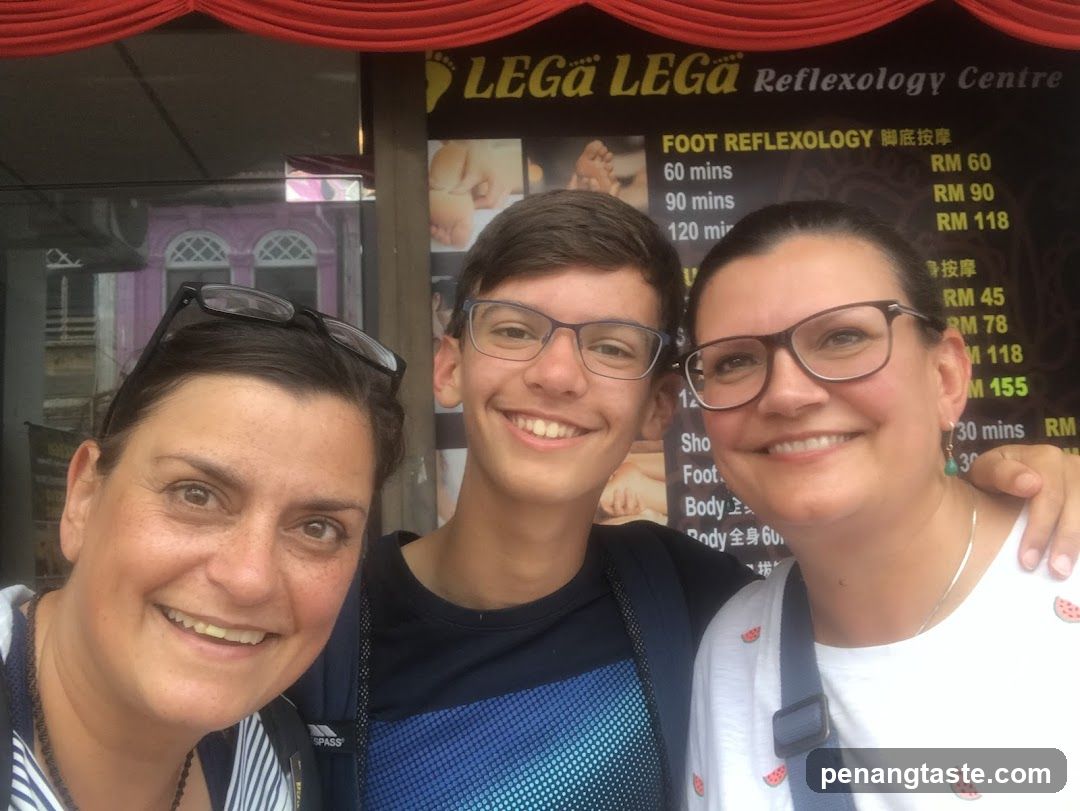 Three people posing in front of a reflexology center