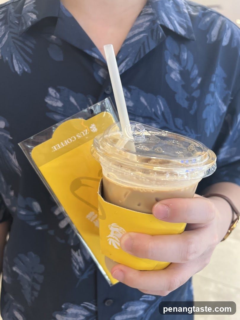 Person holding coffee and branded sleeve