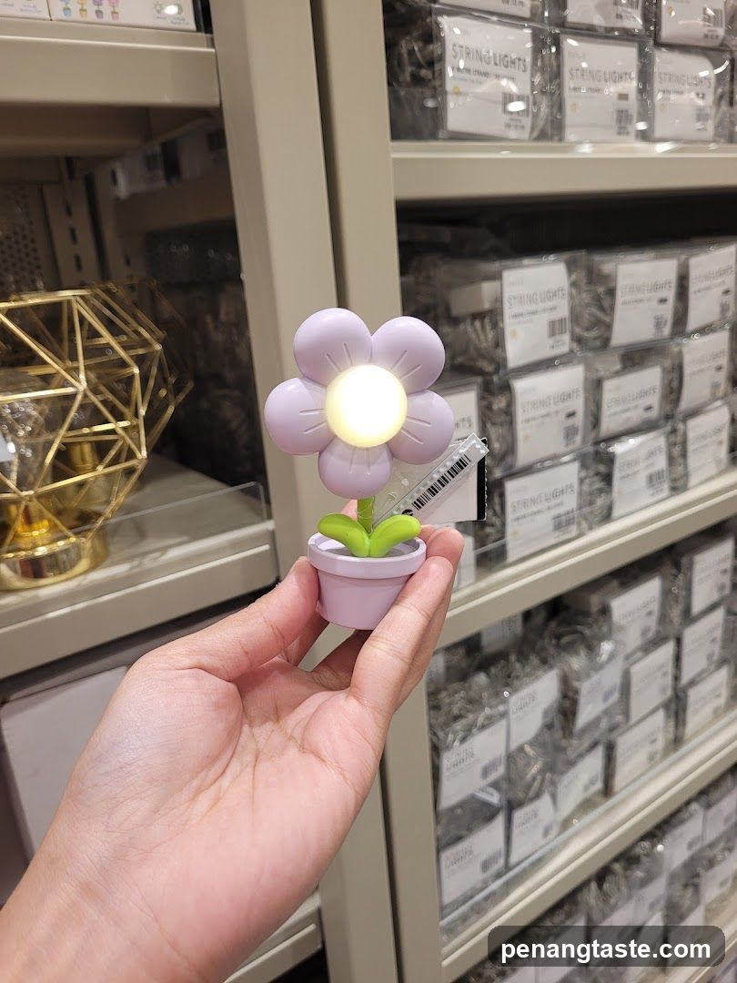 Hand holding flower-shaped LED light in store