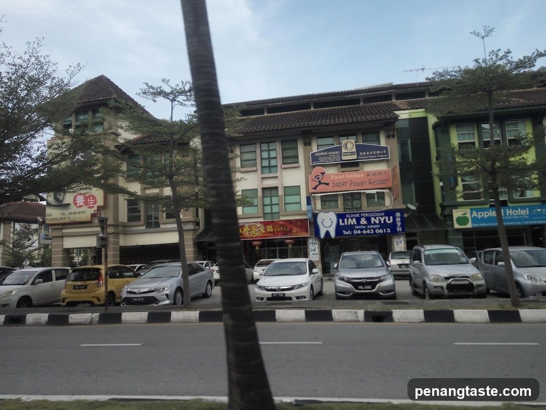 Street view of commercial buildings with parked cars and signage