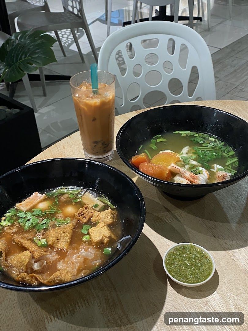 Bowl of soup with iced coffee and green sauce