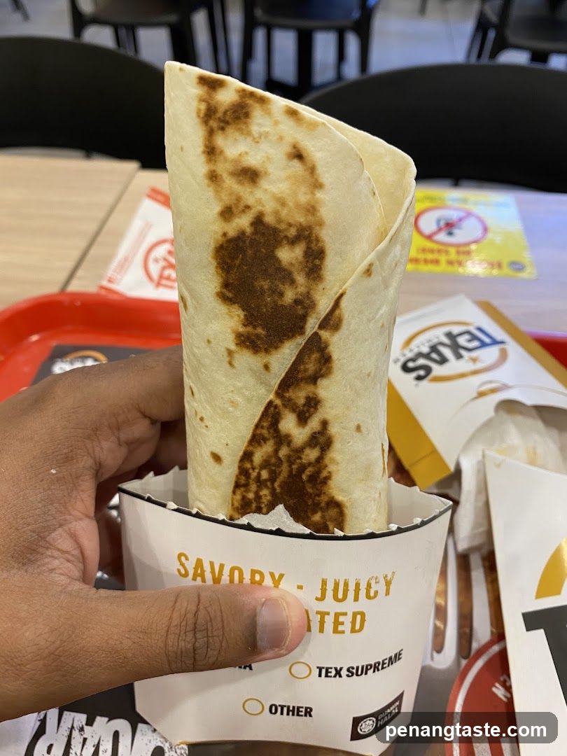 Hand holding a wrapped food item