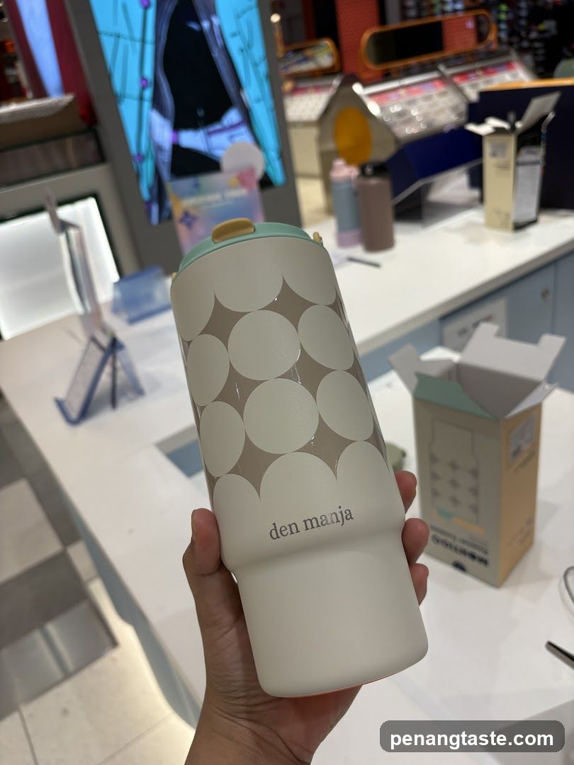 Hand holding a branded water bottle in store interior
