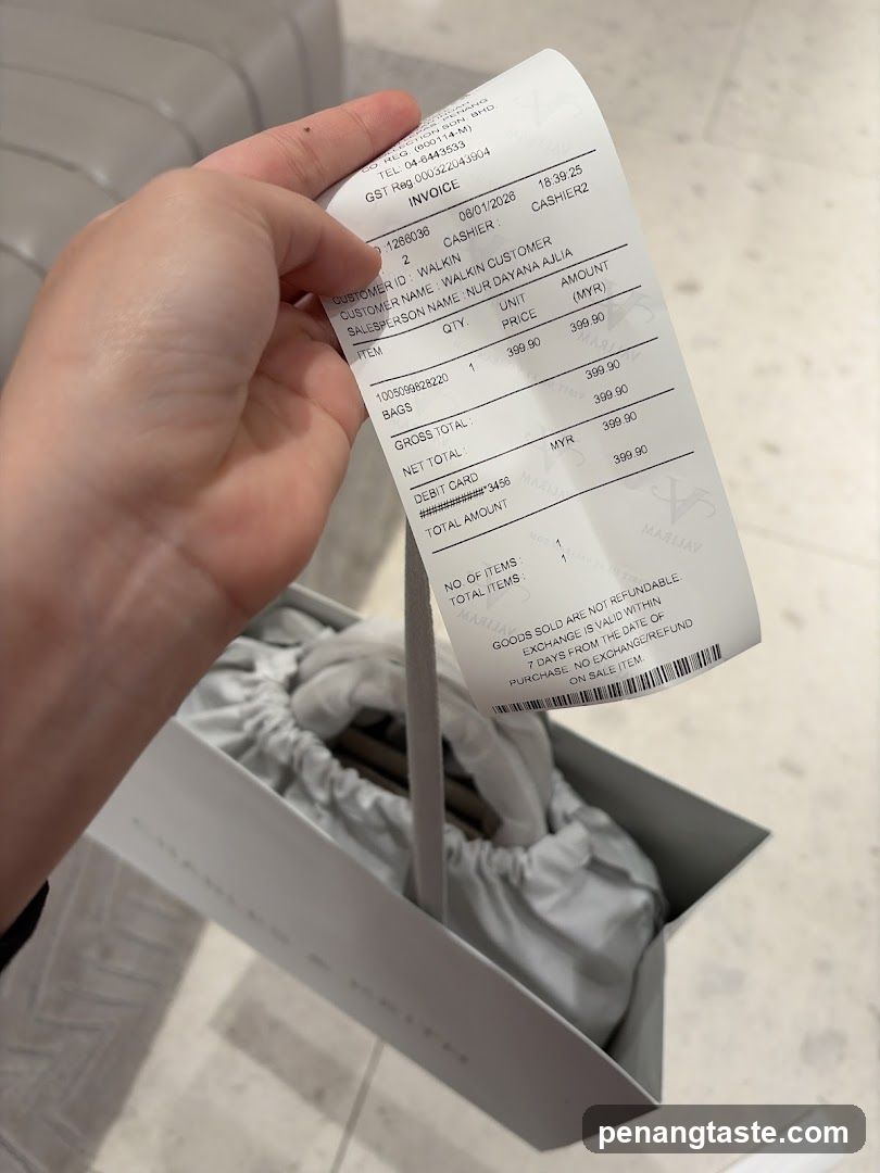 Hand holding receipt with shopping bag