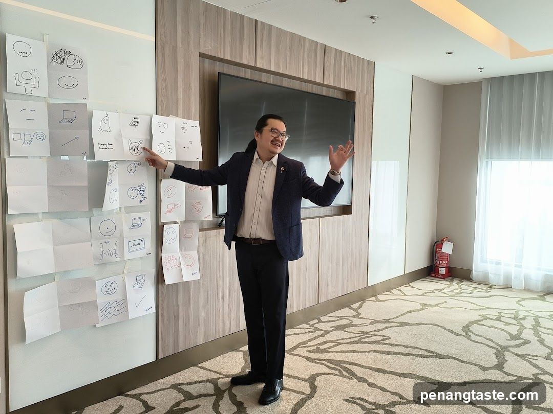 Man presenting drawings on a wall
