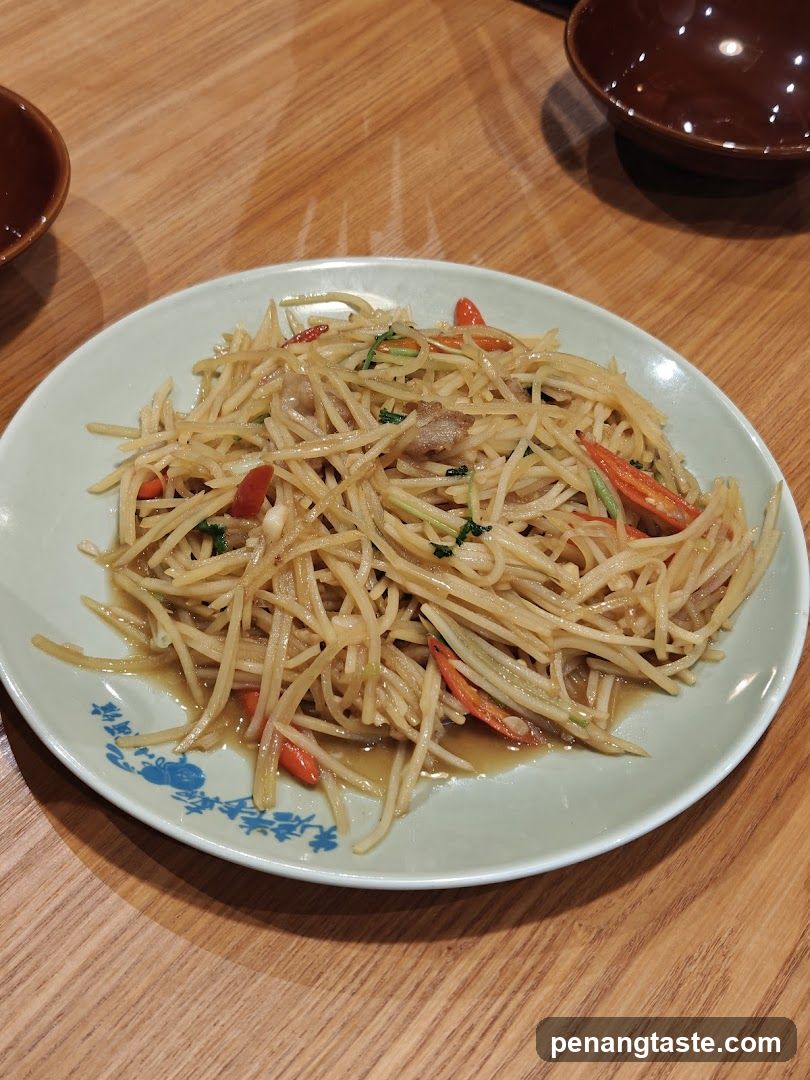 Stir-fried shredded potatoes with chili and herbs