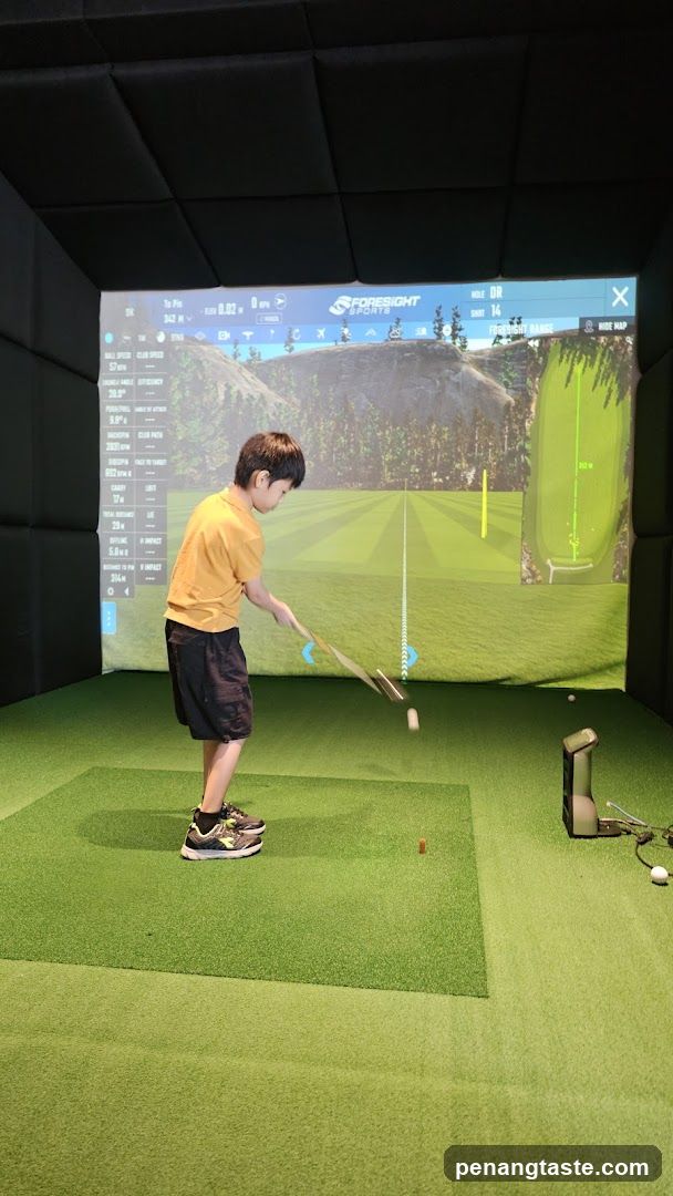 Boy playing indoor golf simulator