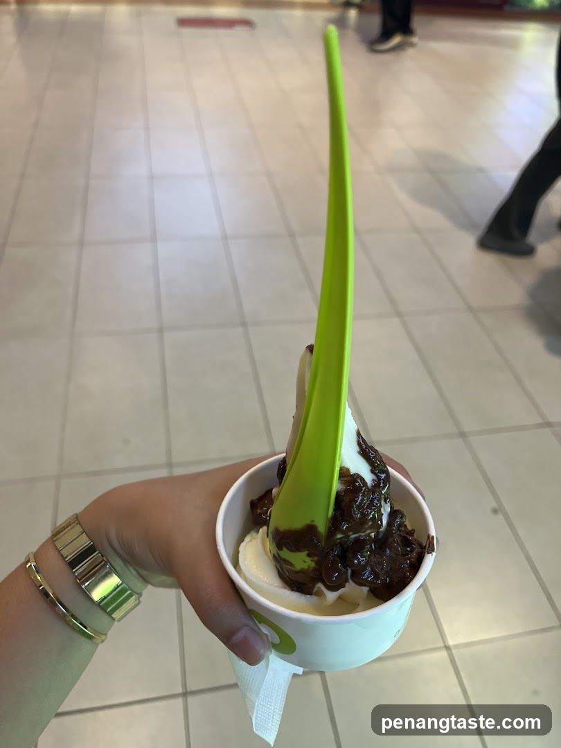 Hand holding frozen yogurt with spoon