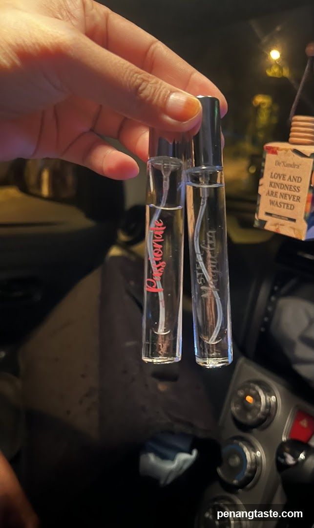 Hand holding two perfume vials