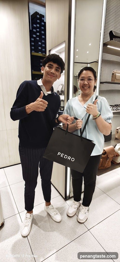 Two people posing with shopping bag in store