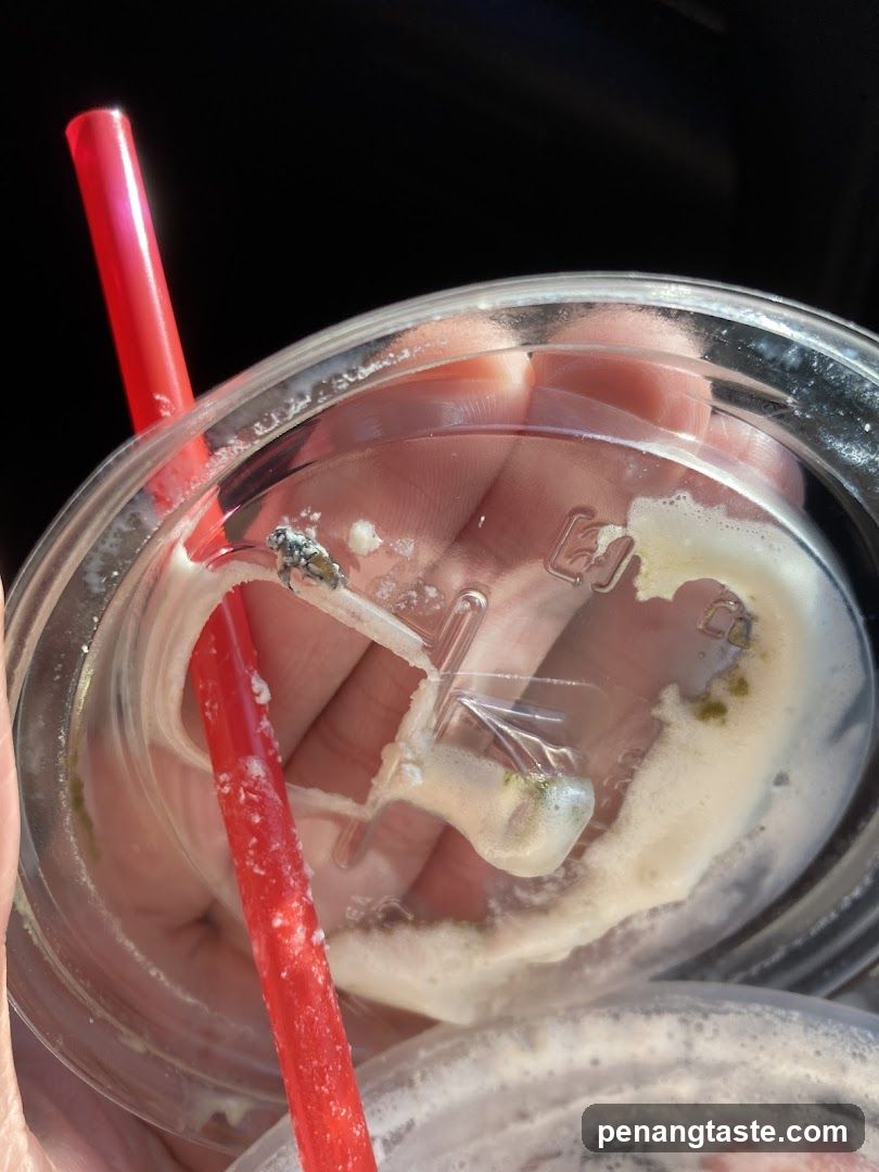 Hand holding a used beverage cup